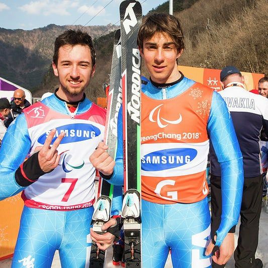 Bertagnolli e Casal in posa, scii in mano, festeggiano il secondo oro paralimpico