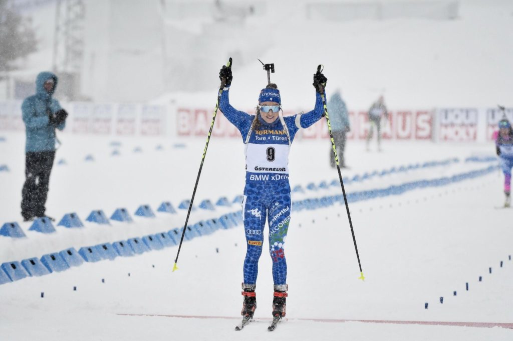 Dorothea Wierer, braccia alzate all'arrivo, festeggia la vittoria nella gara di partenza in linea: l'azzurra è la prima biatleta Italiana nella storia a vincere un oro ai Mondiali